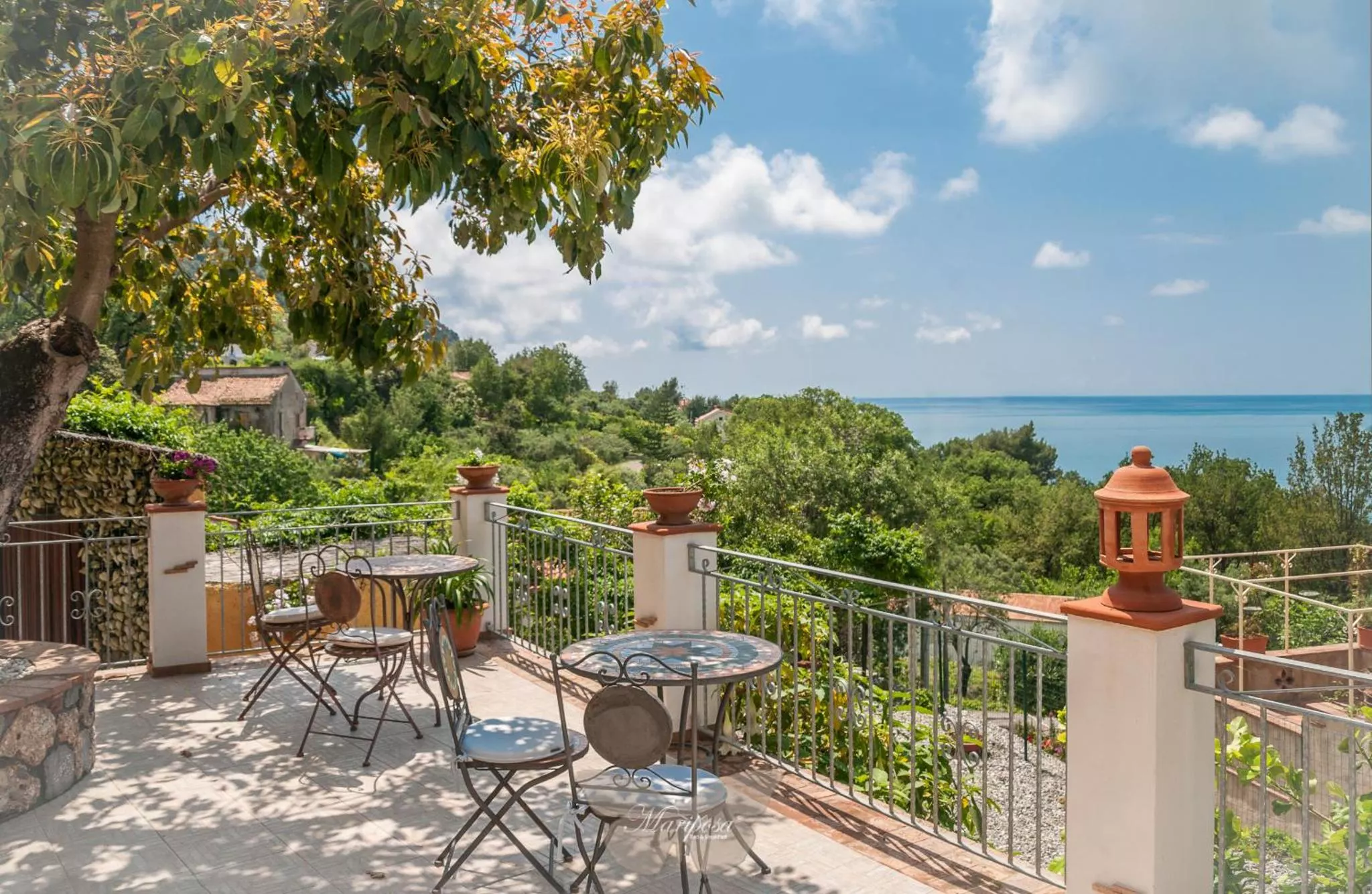 La terrazza del B&B Mariposa a Cersuta, con i tavolini in ferro battuto e il mare di Maratea
