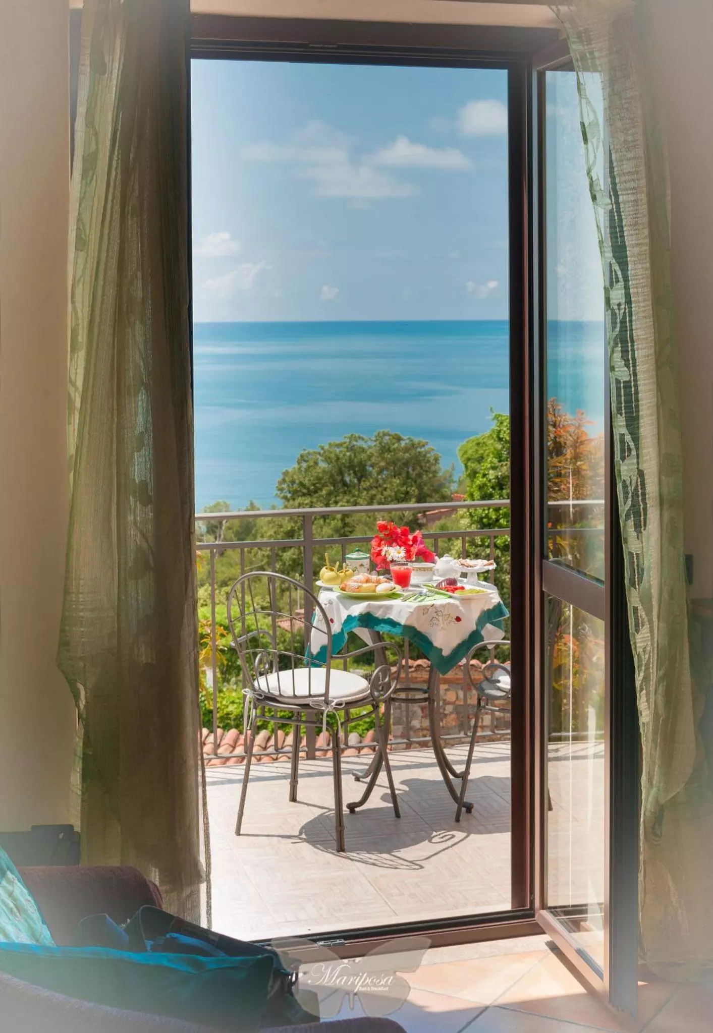 La porta-finestra della camera aperta sul terrazzino e sul mare